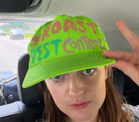 a woman in a car wearing a green hat with the words'taste control'