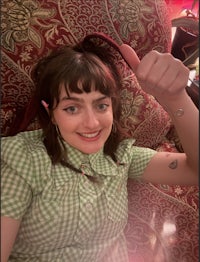 a woman laying on a couch with a thumbs up